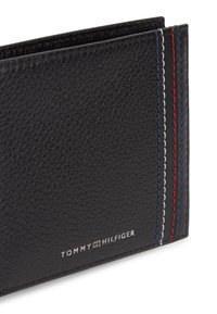 Μαύρο πορτοφόλι από δερμα με υφή, με ραφές σε κόκκινο, άσπρο και μπλε και μικρό ασημένιο λογότυπο Tommy Hilfiger στην κάτω δεξιά γωνία.