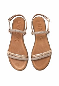 Sandalias de bronce con dos tiras planas, una lisa y otra adornada con pequeñas cuentas, sobre una plantilla marrón texturizada. Presente una correa ajustable en el tobillo.