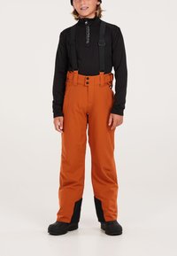 Pantaloni da neve arancioni con bretelle nere regolabili, chiusura con due bottoni e dettagli neri ai polsini, realizzati in materiale resistente.