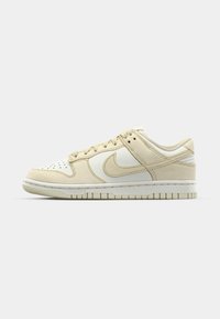 Beige Nike-Sneaker mit einer Oberseite aus Wildleder und Leder, perforierter Zehenpartie, gepolstertem Kragen und gummierter Sohle mit Textur sowie einem kontrastierenden Logo.