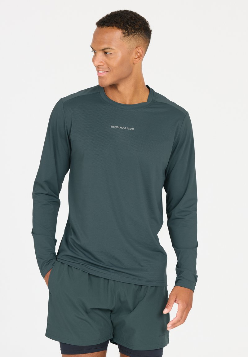 Langärmliges Sportshirt aus dunkelgrünem Stoff mit glatter Textur. Verfügt über einen runden Ausschnitt und ein dezentes "ENDURANCE"-Logo auf der Brust.