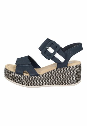 Black wedge sandal with woven-pattern platform, adjustable white-accented buckle strap, and velcro toe strap.
