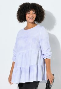 Lichtpaars topje met een ronde halslijn, lange mouwen en een gelaagde ruches ontwerp. Gemaakt van zachte, textuurrijke stof. Inclusief zwarte handtas.