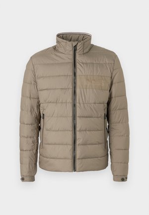 Padded jacket v svetlo hnedej farbe, s vysokým golierom, predným zipsom a bočnými vreckami. Texturovaná tkanina s horizontálnym šitím a logom ako akcentom.