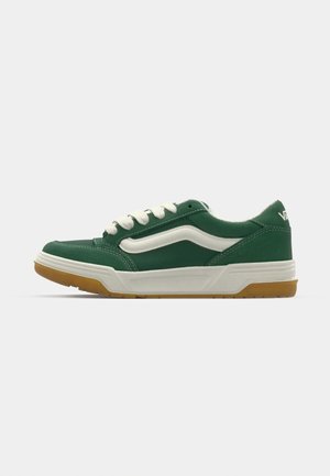 Green sneaker with white accents, featuring a smooth leather upper, rubber sole, and lace-up design. Includes a textured gum outsole.