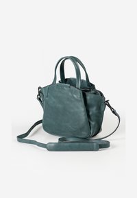 Kleine teal leren handtas met dubbele handvatten, afneembare schouderband en een ritssluiting aan de bovenkant, met een gladde textuur en een minimalistisch ontwerp.