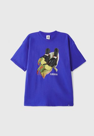 Blue cotton short-sleeve t-shirt featuring a graphic of two toucans. Includes "ALL CONDITIONS GEAR" text near the design.