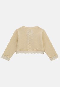 Maglione corto di colore crema con maniche lunghe. Presenta un orlo a scallop e un motivo a trecce lungo la schiena. Tessuto morbido.