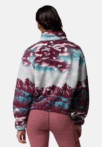 Sudadera de forro polar con un patrón multicolor en burdeos, verde azulado y blanco. Presenta un cuello alto y un corte relajado. Superficie texturizada con motivo de montañas.