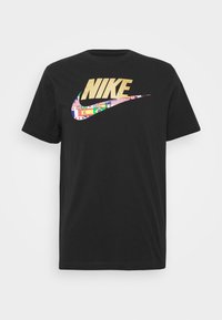 Svart kortärmad Nike T-shirt med guld-logotyp och swoosh, fylld med olika internationella flaggor på framsidan i mitten.