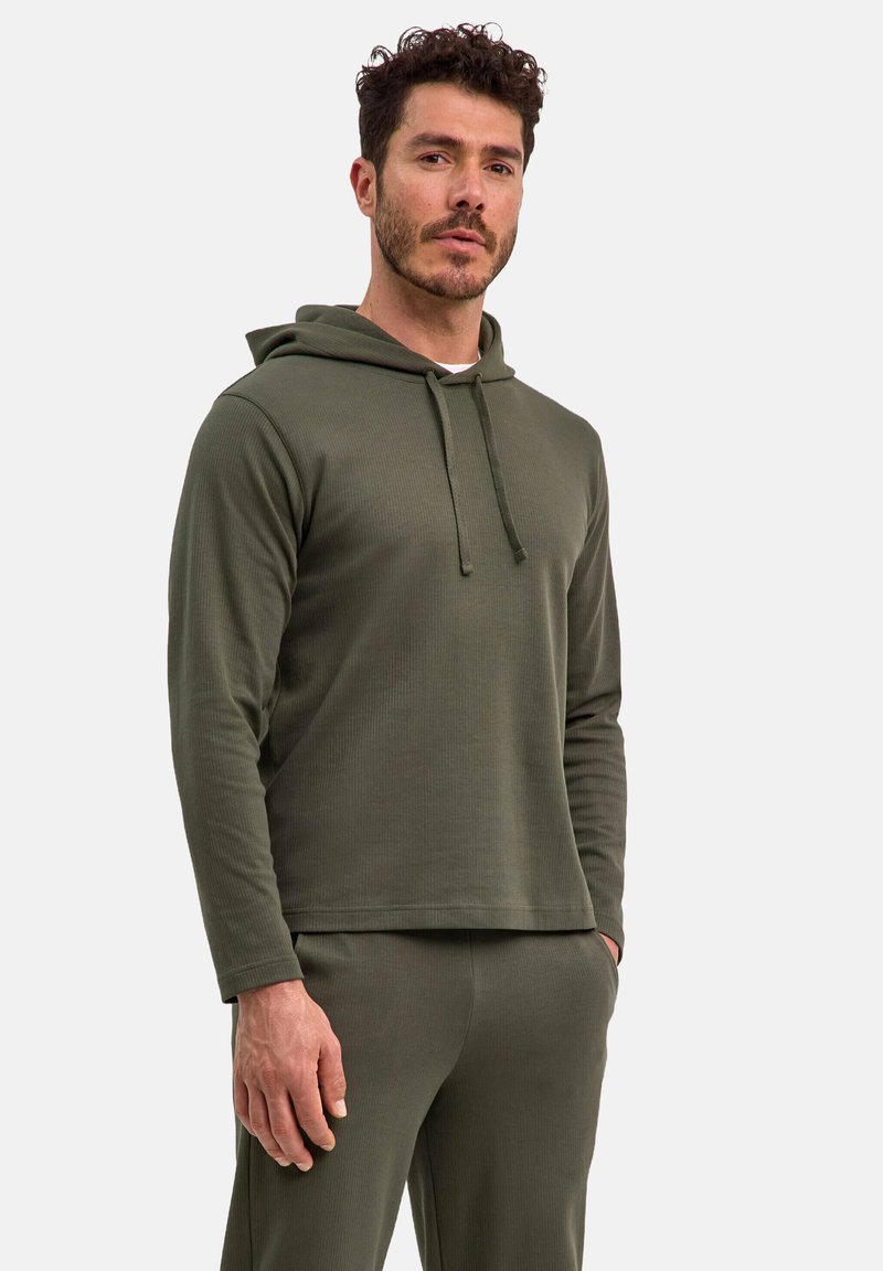 Felpa verde oliva in tessuto a costine con cappuccio regolabile, maniche lunghe e vestibilità ampia, abbinata a pantaloni coordinati.