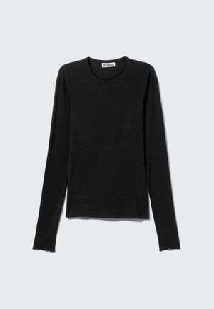 Juoda ilgomis rankovėmis marškinėliai iš minkštos medžiagos su apvalia iškirpte. Apačia turi nebaigtą kraštą, suteikiantį laisvą išvaizdą.