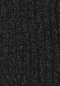Tessuto nero strutturato con un motivo a coste, morbido al tatto e con fibre sottili, che conferisce un aspetto leggermente peloso.