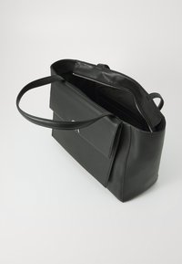 Black leather handbag with a structured shape, featuring a zip closure, slim handles, and a front pocket for storage. Smooth texture.
