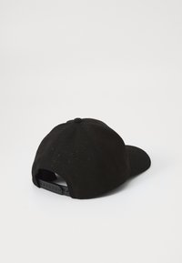 Schwarze Mütze mit strukturiertem Muster, runder Krone und verstellbarem Riemen hinten. Hergestellt aus einem Stoff mit matter Oberfläche.