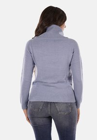 Maglione lavorato a maglia azzurro chiaro con colletto alto, tessuto testurizzato, design aderente e dettagli a coste all'orlo e ai polsini.
