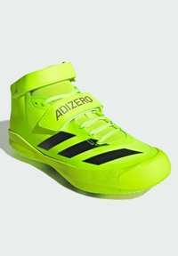 Chaussure de sport de couleur vert fluo avec un design montante. Elle présente des rayures noires, une sangle réfléchissante étiquetée "ADIZERO", et des matériaux texturés.