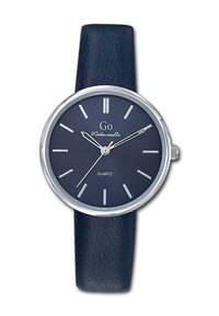 Montre quartz ronde avec un bracelet en cuir texturé bleu foncé, des éléments en métal argenté, et un cadran marine assorti avec des index horaires et le nom de la marque.