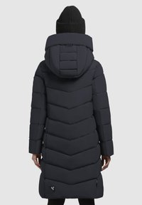 Manteau noir long matelassé avec une capuche, présentant un motif en chevrons, des poignets élastiques et un détail logo près de l'ourlet.