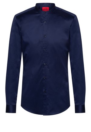 Marineblaues Hemd mit langen Ärmeln, Stehkragen, durchgehender Knopfleiste und rotem Innenetikett am Kragen.
