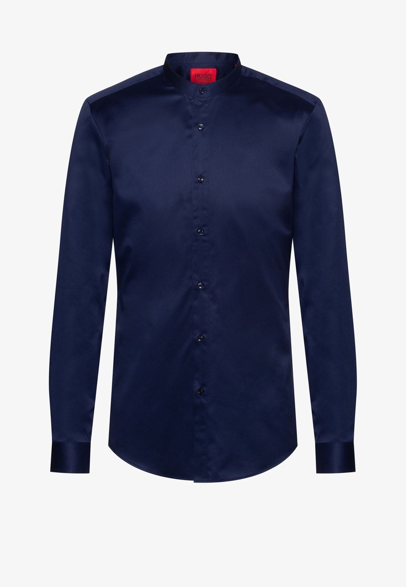 Chemise longue à manches longues bleu marine avec col mandarin, patte de boutonnage devant, et étiquette intérieure de col rouge.