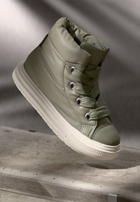 Olive green padded high-top sneaker with gray accents, round toe, flat white sole, and metal eyelets, featuring laces in matching color.