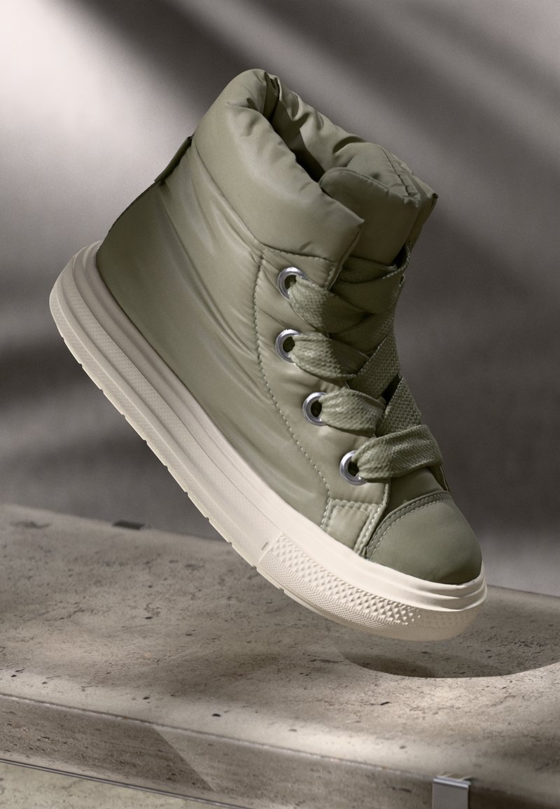 Olive green padded high-top sneaker with gray accents, round toe, flat white sole, and metal eyelets, featuring laces in matching color.