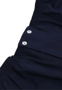 Camicia button-up blu navy con una texture morbida, vita elasticizzata e due bottoni bianchi davanti, progettata per il comfort.