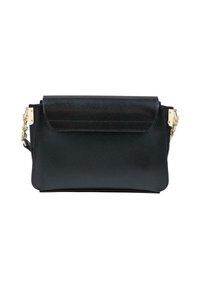 Sac en cuir noir avec fermeture rabat et chaîne dorée sur fond blanc, vu de face.