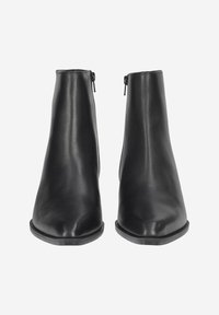 Bottines en cuir noir avec une texture lisse, bout pointu, fermeture à glissière sur le côté et un design minimaliste, présentées sur un fond blanc.