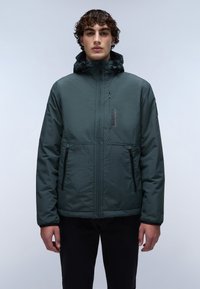 Chaqueta aislante de color verde oscuro con un alto collar, cremallera frontal y múltiples bolsillos con cremallera. Presenta una tela texturizada y una capucha ajustable.