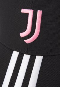 Sort kasket med et pink broderet logo og tre hvide striber. Stoffet har en tekstureret overflade med en struktureret form.