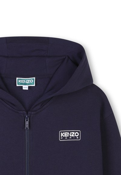 Sweat à capuche zippé marine avec une texture douce, arborant un logo blanc "KENZO PARIS" sur la poitrine et une grande capuche.