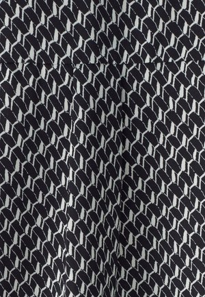 Black fabric featuring a repeating geometric pattern in white, consisting of interlocking shapes with a slight textured finish.