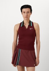 Tenue de tennis bordeaux comprenant un haut sans manches avec un col en V et un col vert, associé à une jupe plissée. Rayures bleues accentuées sur le col et la jupe.