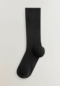 Sort sok lavet af glat materiale, med forstærket hæl og tå. Designet er enkelt med en ribbet kant øverst.