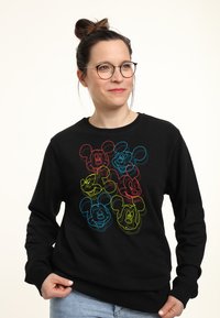 Svart sweatshirt med sex flerfärgade konturer av ett tecknat mus huvud. Designen inkluderar röda, blå, gula och gröna accenter.