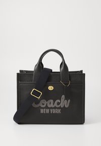 Musta nahkainen käsilaukku, jossa on tekstuuri, varustettuna "Coach New York" -tekstillä harmaalla värillä, tuplakahvoilla ja irrotettavalla olkahihnalla. Kultainen metalliosuus.