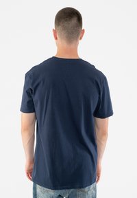 Navy blue cotton t-shirt with short sleeves, round neckline, and a smooth texture, displayed from the back. No visible logos or patterns.