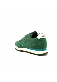 La sneaker verde in suede presenta un tallone bianco con "1968", accenti turchesi e un design testurizzato con una suola cushioned.