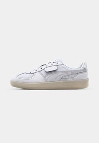 Sneakers z białą skórzaną cholewką, z chropowatym wzorem, systemem sznurowania i beżową gumową podeszwą. Wytłoczone logo Pumy po bokach.