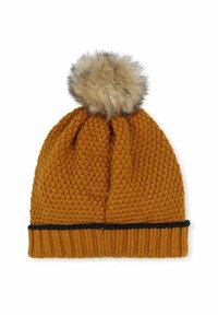 Bonnet en tricot jaune moutarde avec un motif texturé et un pompon en fausse fourrure sur le dessus. Présente une bande repliée bleu marine en bas.