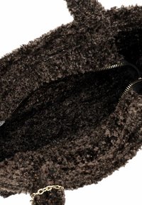 Ruda dirbtinės odos rankinė su minkšta tekstūra, juoda pamušalu, auksine užtrauktuku ir grandinės akcentu išorėje.