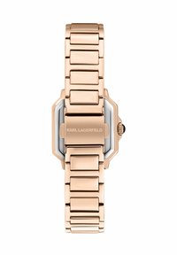 Orologio in metallo color oro rosa con cassa rettangolare, maglie del bracciale spazzolate e lucide, e dettaglio della corona nera. Presenta una incisione con la scritta "KARL LAGERFELD".