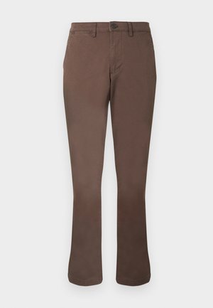 Brūnas taisnas ikdienas bikses ar jostas cilpām, priekšpuses pogu un sānu kabatām uz balta fona.