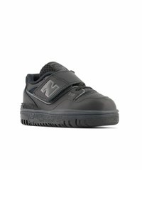 Chaussure de sport noire avec une tige synthétique, des accents en mesh et une sangle à boucle auto-agrippante. Présente une semelle en caoutchouc texturé et une languette rembourrée.