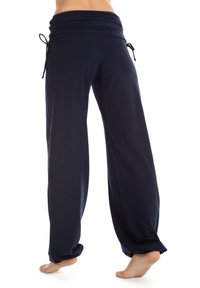 Marineblaue, lässige Hosen aus weichem Stoff, mit einem breiten, gerafften Bund und verstellbarem Kordelzug. Die Hosen verjüngen sich an den Knöcheln.
