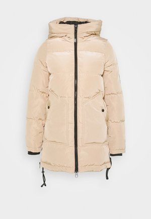 Manteau beige matelassé à capuche, avec une fermeture éclair noire sur le devant, deux grandes poches et des cordons de serrage réglables à l’ourlet.
