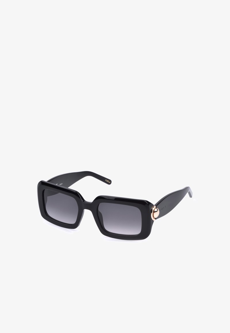 Lunettes de soleil rectangulaires noires avec des montures épaisses et des verres dégradés foncés, avec un petit détail circulaire doré sur chaque branche.