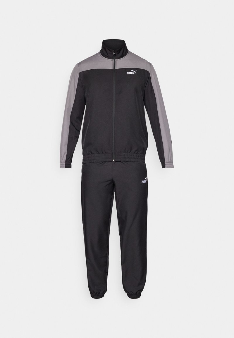Chándal de poliéster negro con detalles en gris, chaqueta con cremallera y pantalones con cintura elástica. Presenta un pequeño logo de Puma en ambas prendas.